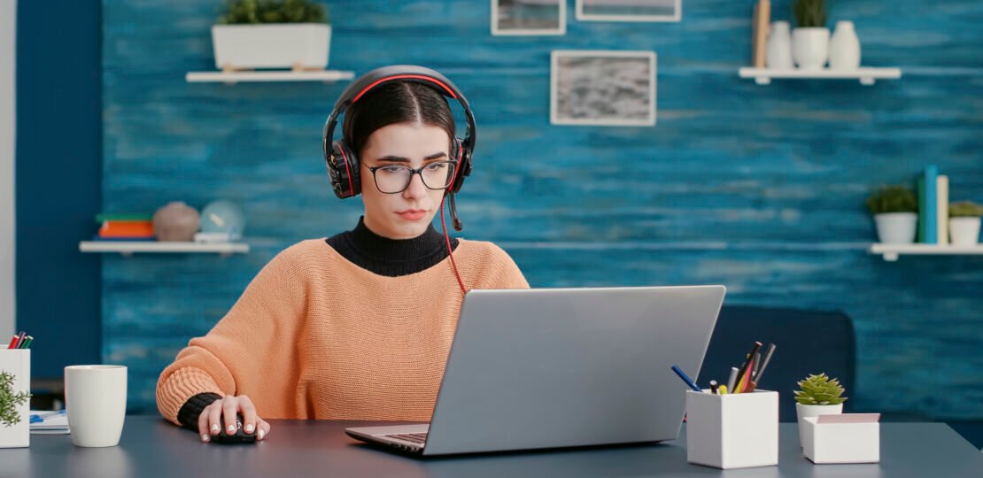University student using headphones and laptop to attend online class